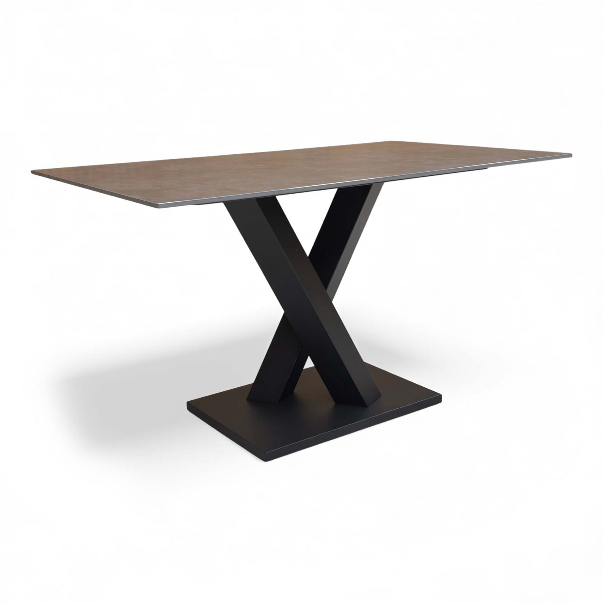 Angled view of the dining table showcasing the grey sintered stone top and V-shaped base.