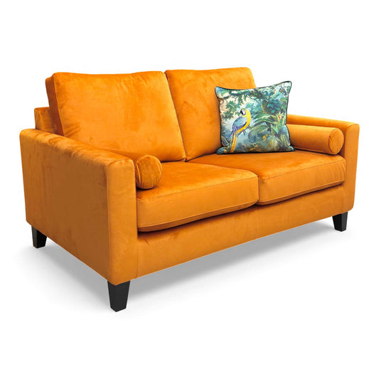 Angled view of the Bailey Primo 2 Seater Sofa upholstered in rich Marigold Velvet, showing the side bolster cushions.