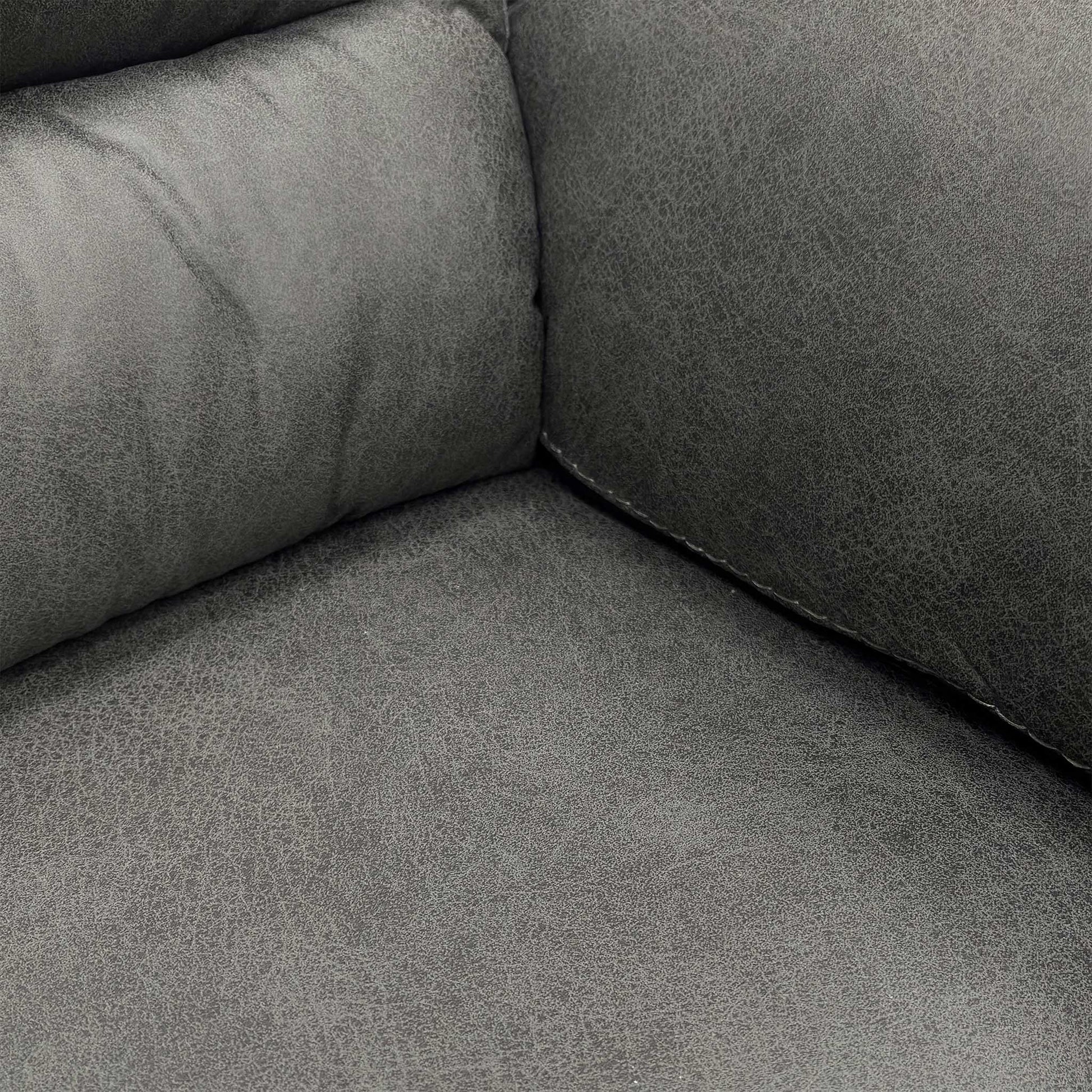 Close-up of the soft Charcoal Grey Microfibre fabric and cushioned backrest of the Vegas sofa.