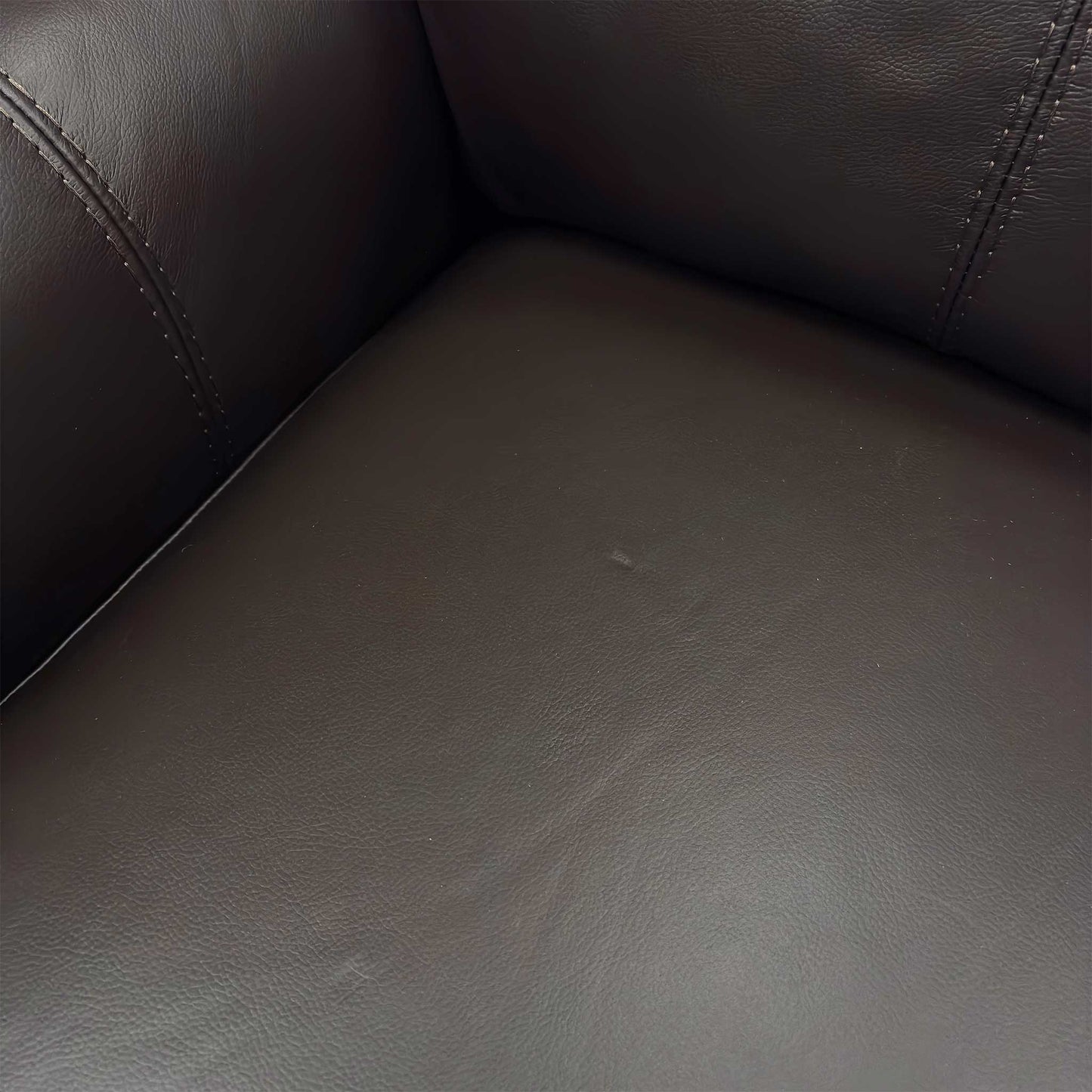 Close-up of the supple, high-quality Dark Chocolate Leather upholstery texture and stitching details.