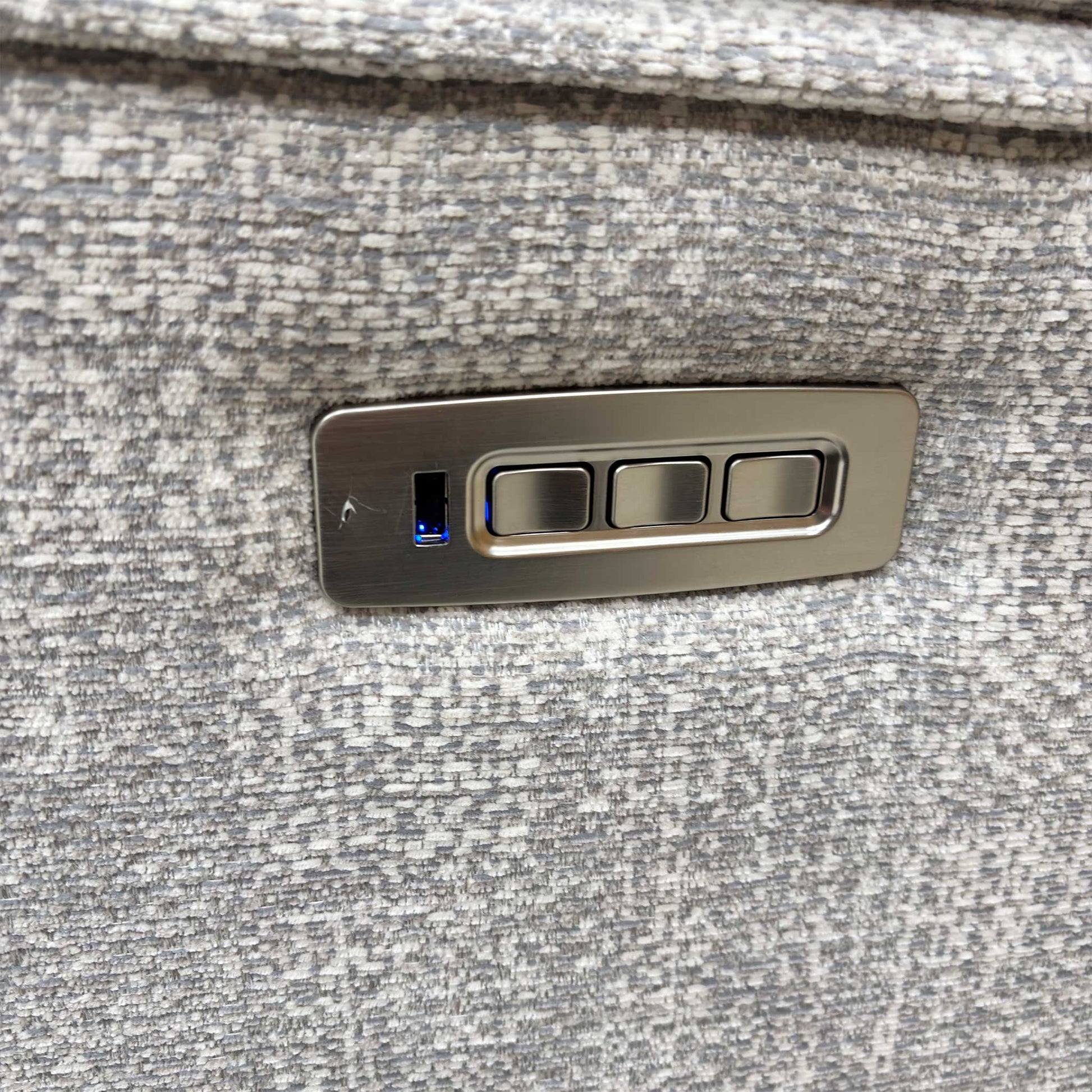 Detail of the power control buttons and USB charging port on the armrest.