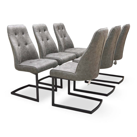 Full view of the set of six ‘Merlin’ Cantilever Dining Chairs in Charcoal Grey Fabric (H 98 cm, W 51 cm) in a dining room setting.