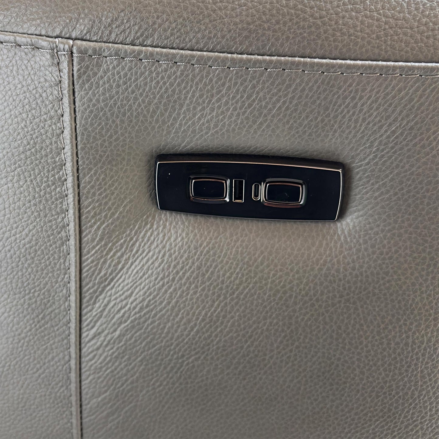 Close-up of the wireless, USB, and USB-C charging panel on the sofa console.