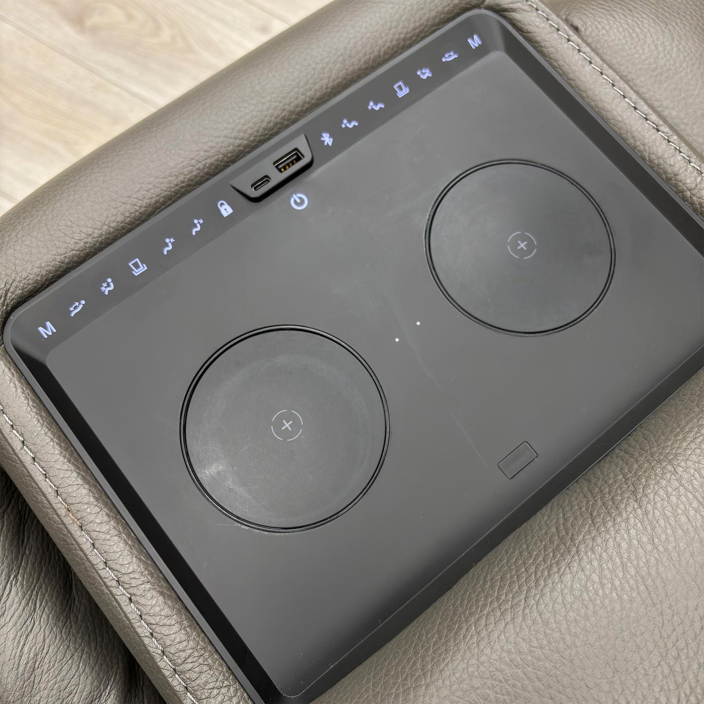 Close-up of the media console on the 2-seater sofa, displaying the cup holders, USB ports, and controls.