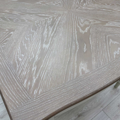 Close-up on the wooden veneer tabletop, highlighting the inlaid marquetry patterning.