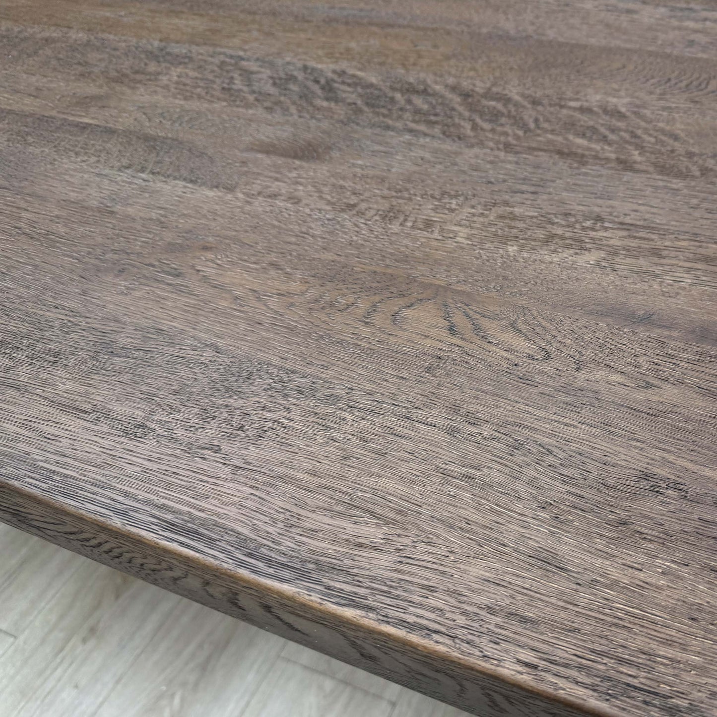 Close-up showing the connection point between the dark oak tabletop and the metal legs.