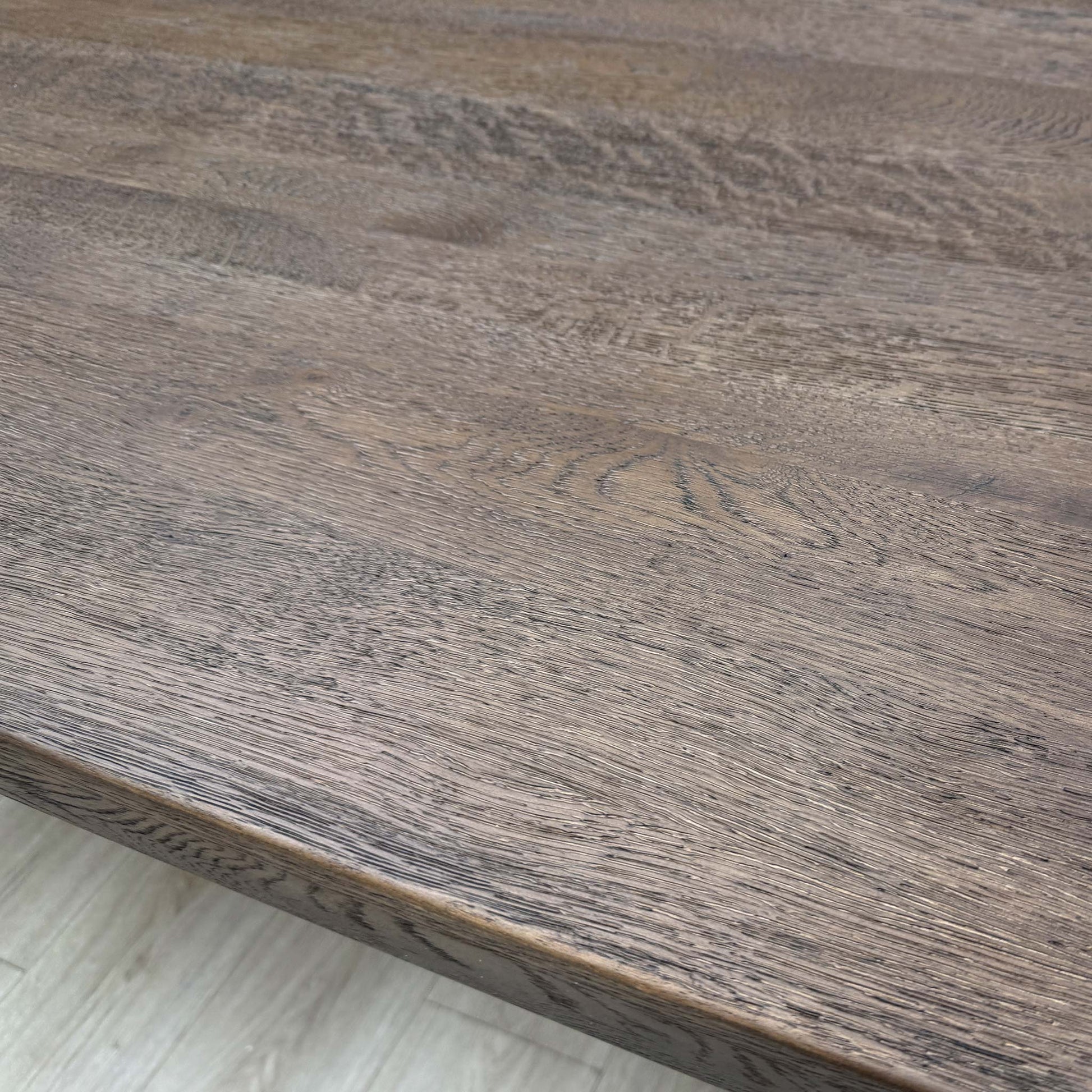 Close-up showing the connection point between the dark oak tabletop and the metal legs.