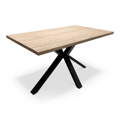 'Saturn' Solid Oak Compact 135cm Fixed Dining Table, angled view on a white background showing the cross-shaped black metal legs