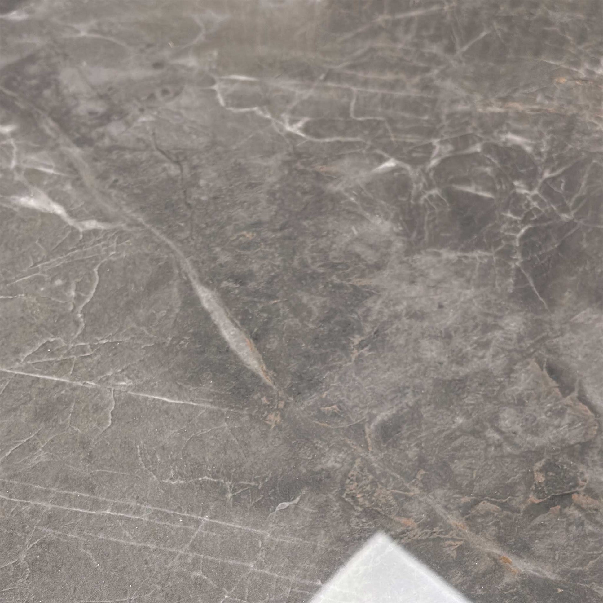 Close-up of the glossy ceramic tabletop, showing the detailed grey marble veining and reflective finish.