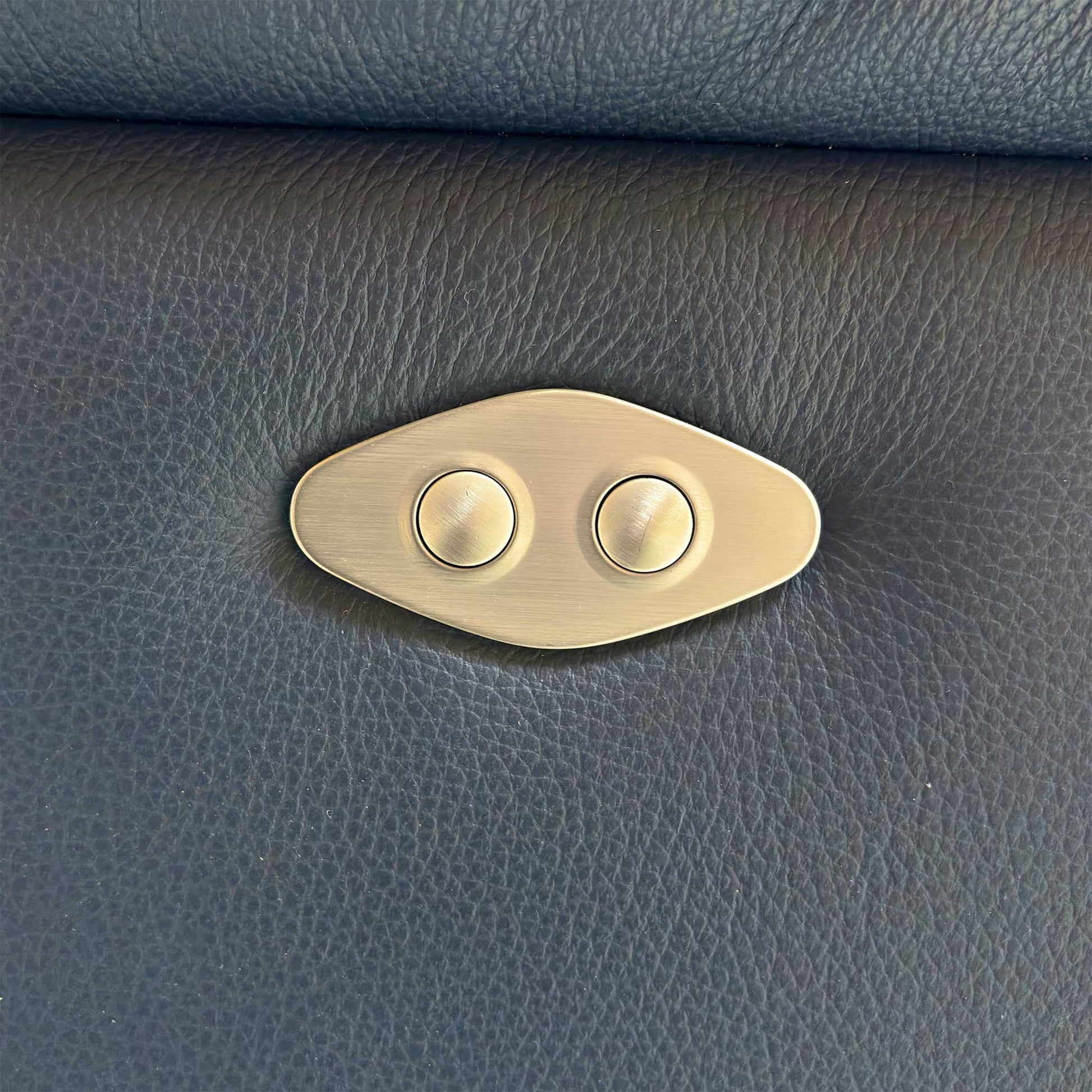 Detail of the power reclining buttons integrated into the side of the sofa for easy reach.