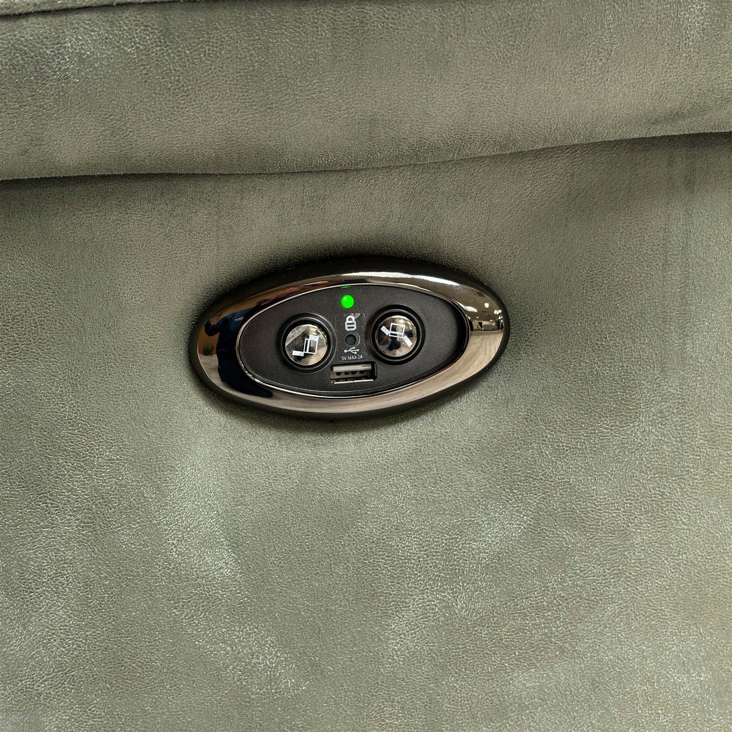 Close-up of the integrated power reclining button and USB charging port on the side of the sofa.