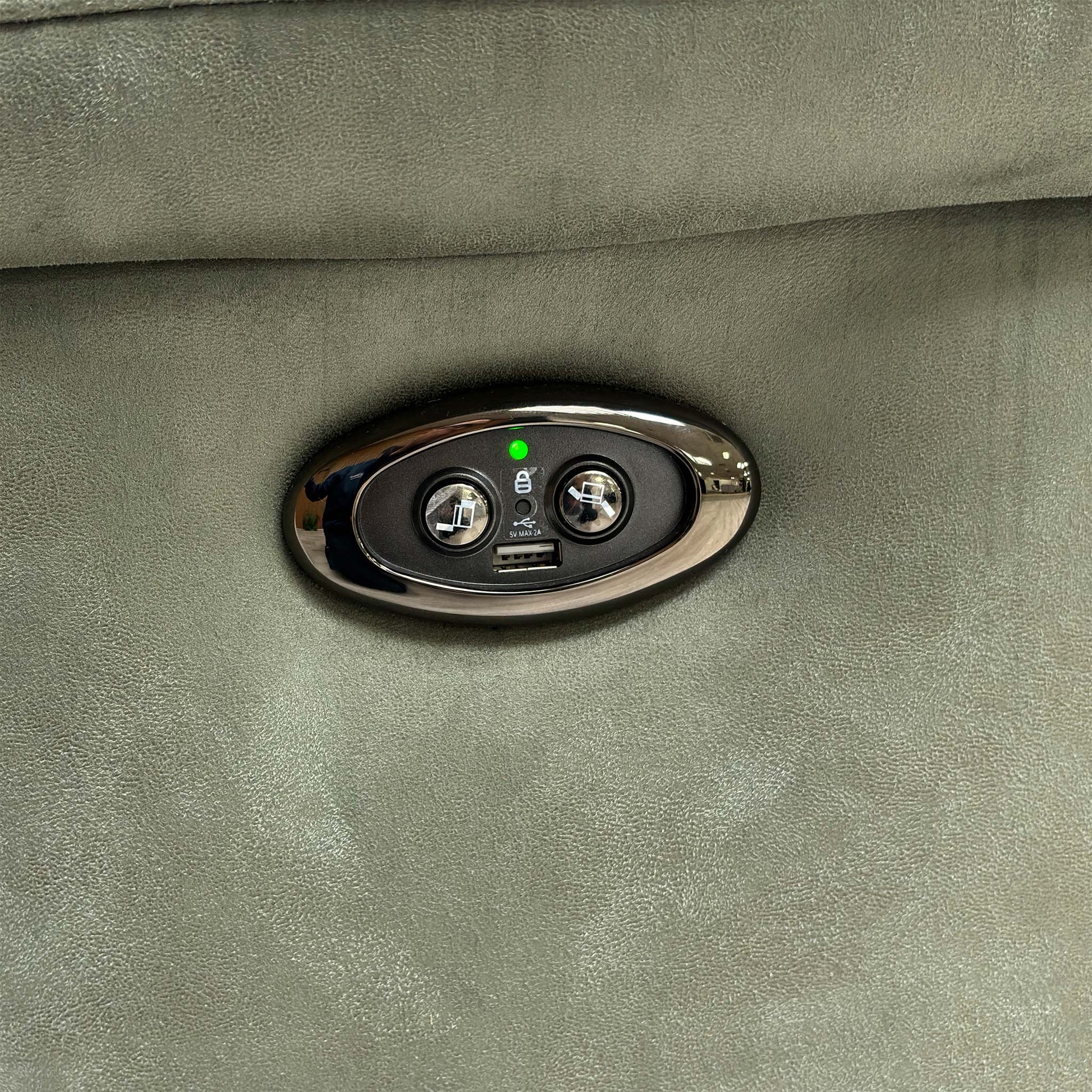 Close-up of the integrated power reclining button and USB charging port on the side of the sofa.