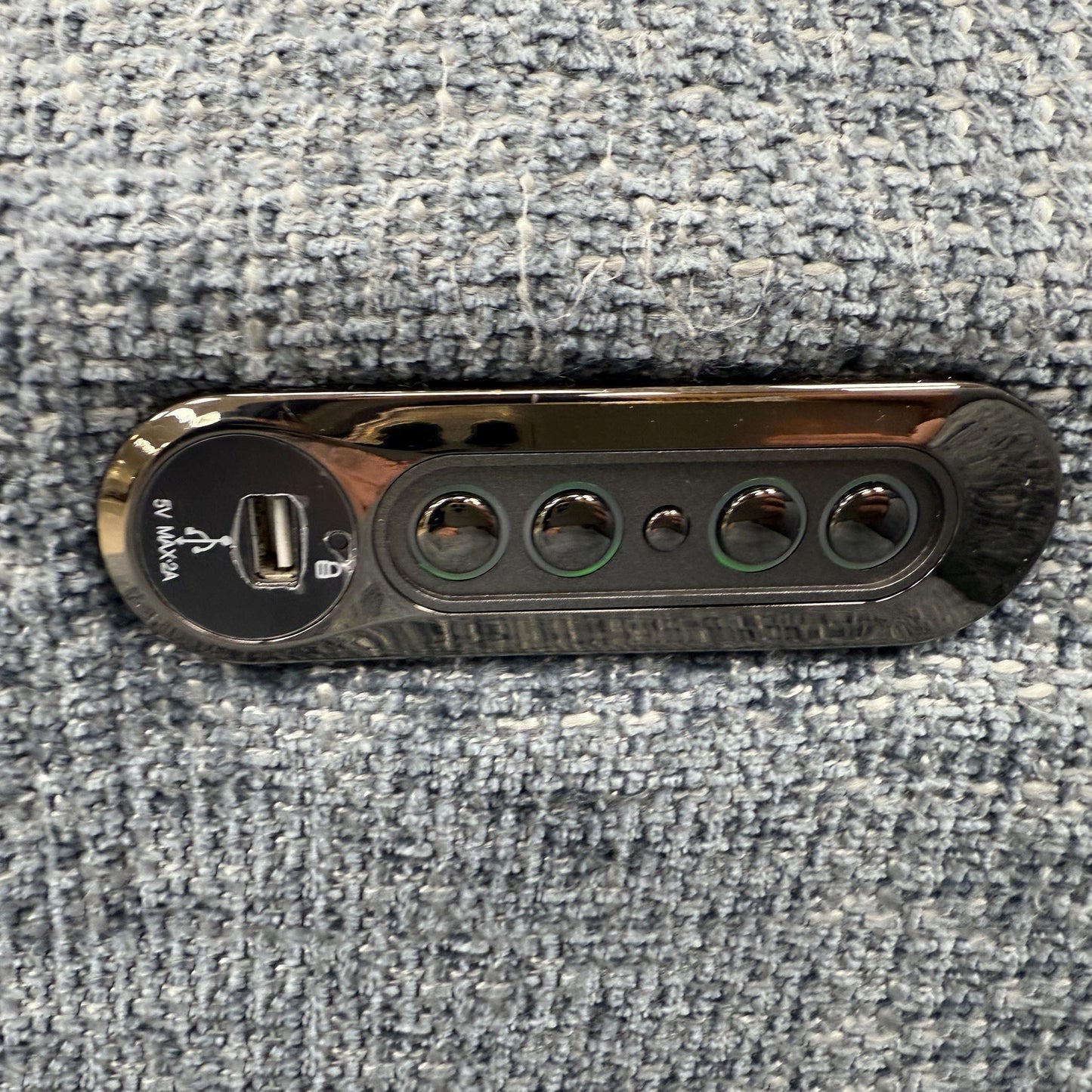 Close-up of the polished metal legs and the contemporary button detailing on the sofa arms.