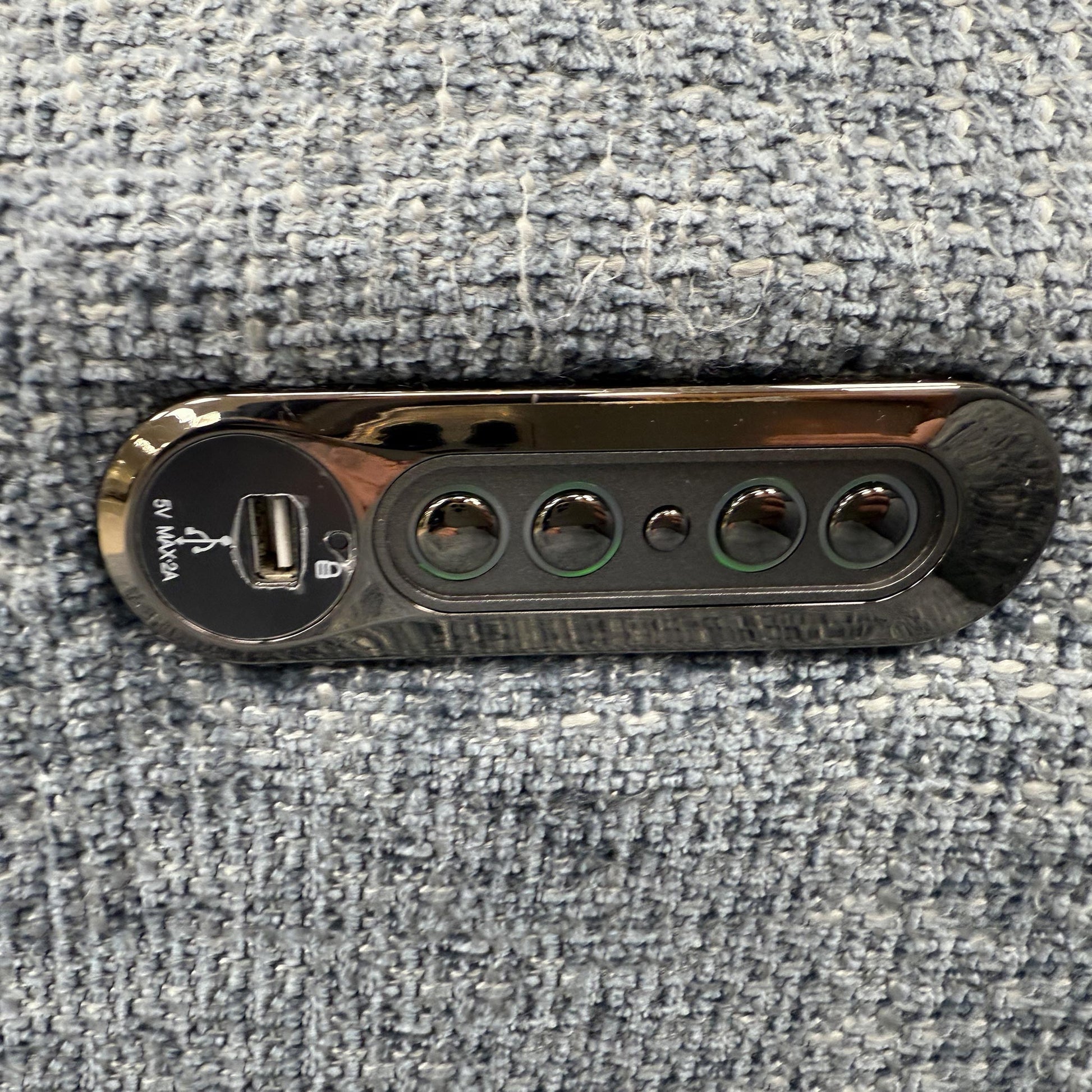 Close-up of the polished metal legs and the contemporary button detailing on the sofa arms.