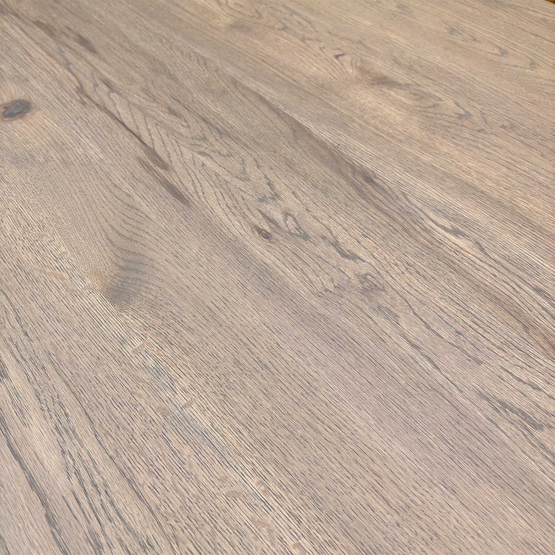 Close-up of vintage grey solid oak tabletop showing natural wood grain, knots, and texture.