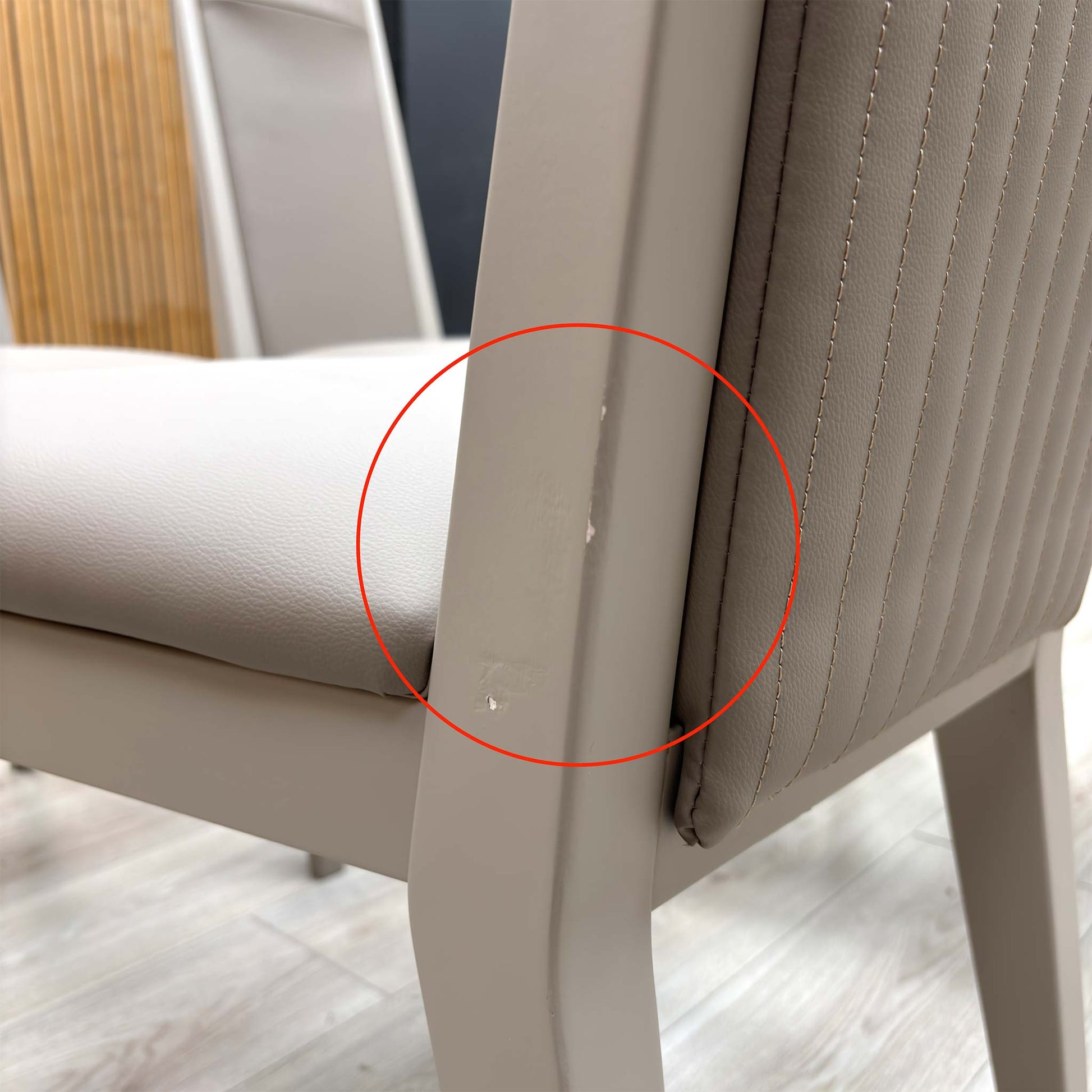 Detail shot of the black powder-coated metal legs, showing the tapered design and the protective feet glides to prevent floor scratching.