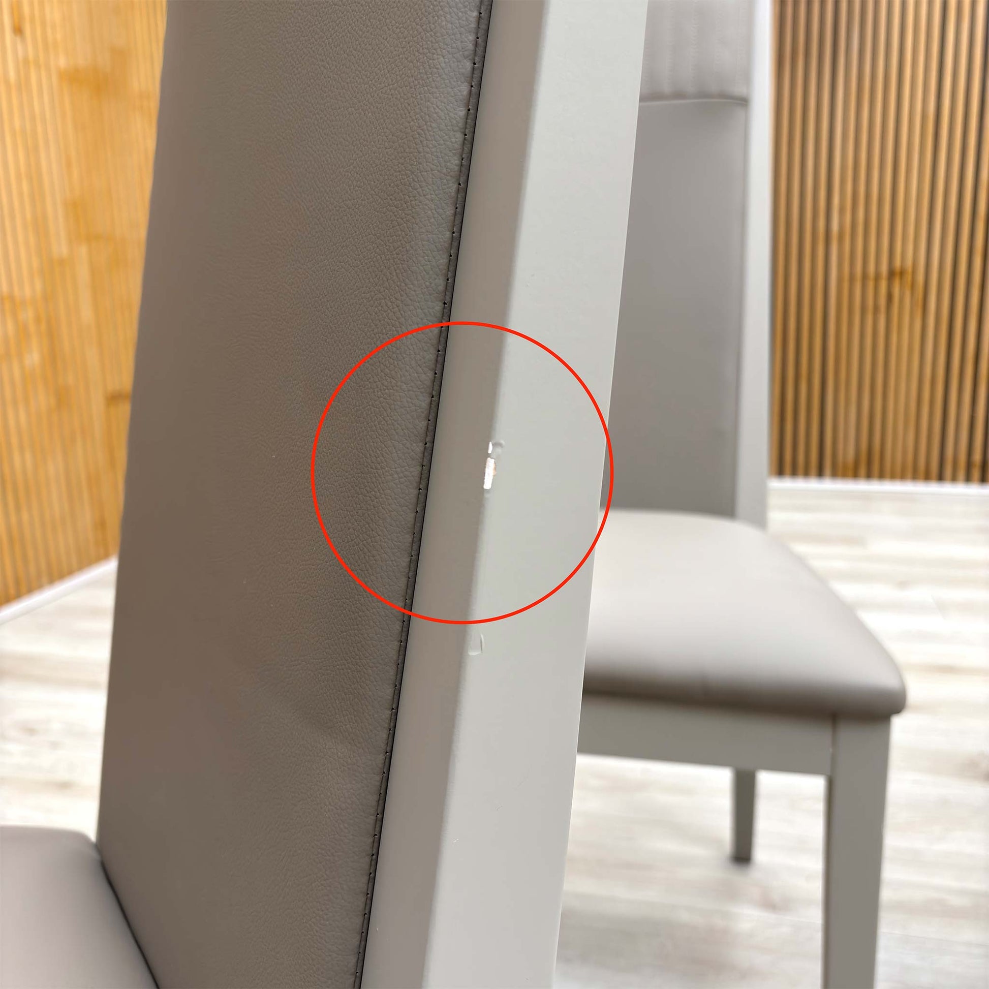 Detail shot of the black powder-coated metal legs, showing the tapered design and the protective feet glides to prevent floor scratching.
