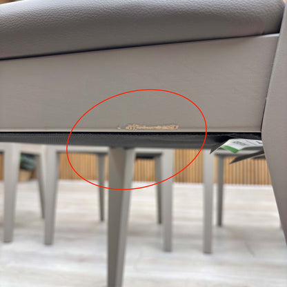 Detail shot of the black powder-coated metal legs, showing the tapered design and the protective feet glides to prevent floor scratching.