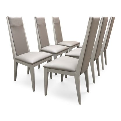 Side view of a Lusso dining chair, showcasing the slim profile, elegant taupe color palette, and the detailed vertical channeled quilting on the backrest.