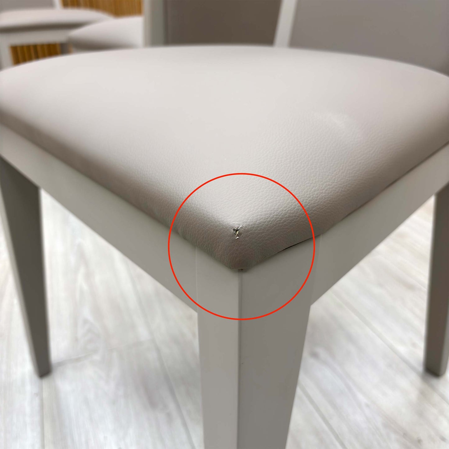 Detail shot of the black powder-coated metal legs, showing the tapered design and the protective feet glides to prevent floor scratching.