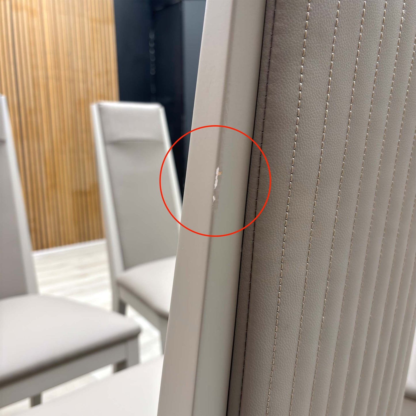 Close-up macro shot of the Taupe faux leather upholstery, highlighting the realistic grain texture and the precise vertical panelled stitching.