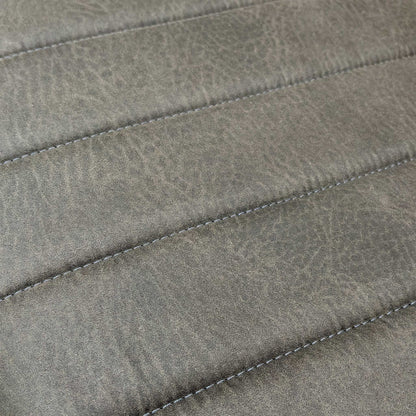Close-up of the dark grey faux leather upholstery and fluted stitching detail on the bench seat.