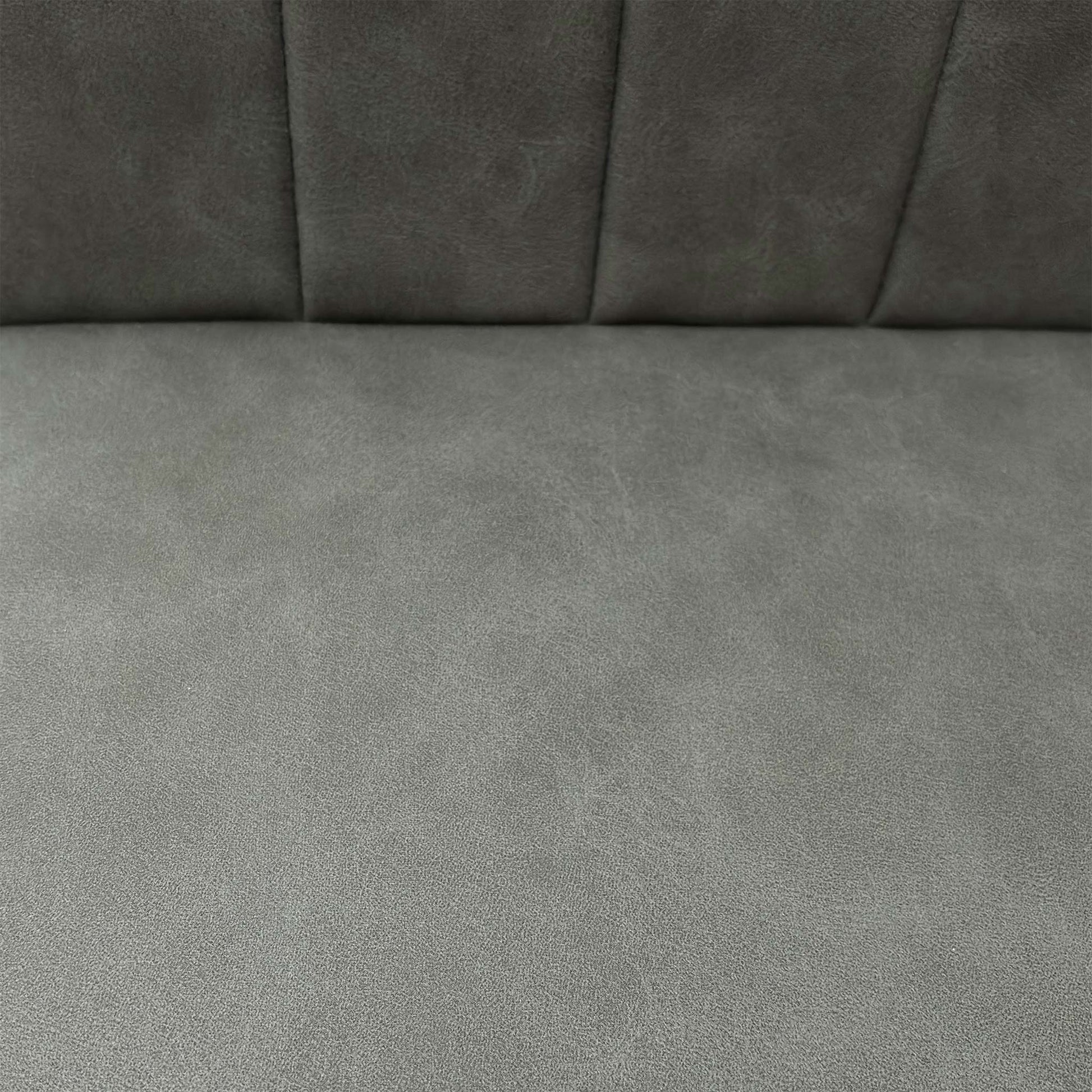Close-up of the grey faux leather upholstery, emphasizing the foam-cushioned seat and precision vertical stitch detailing.