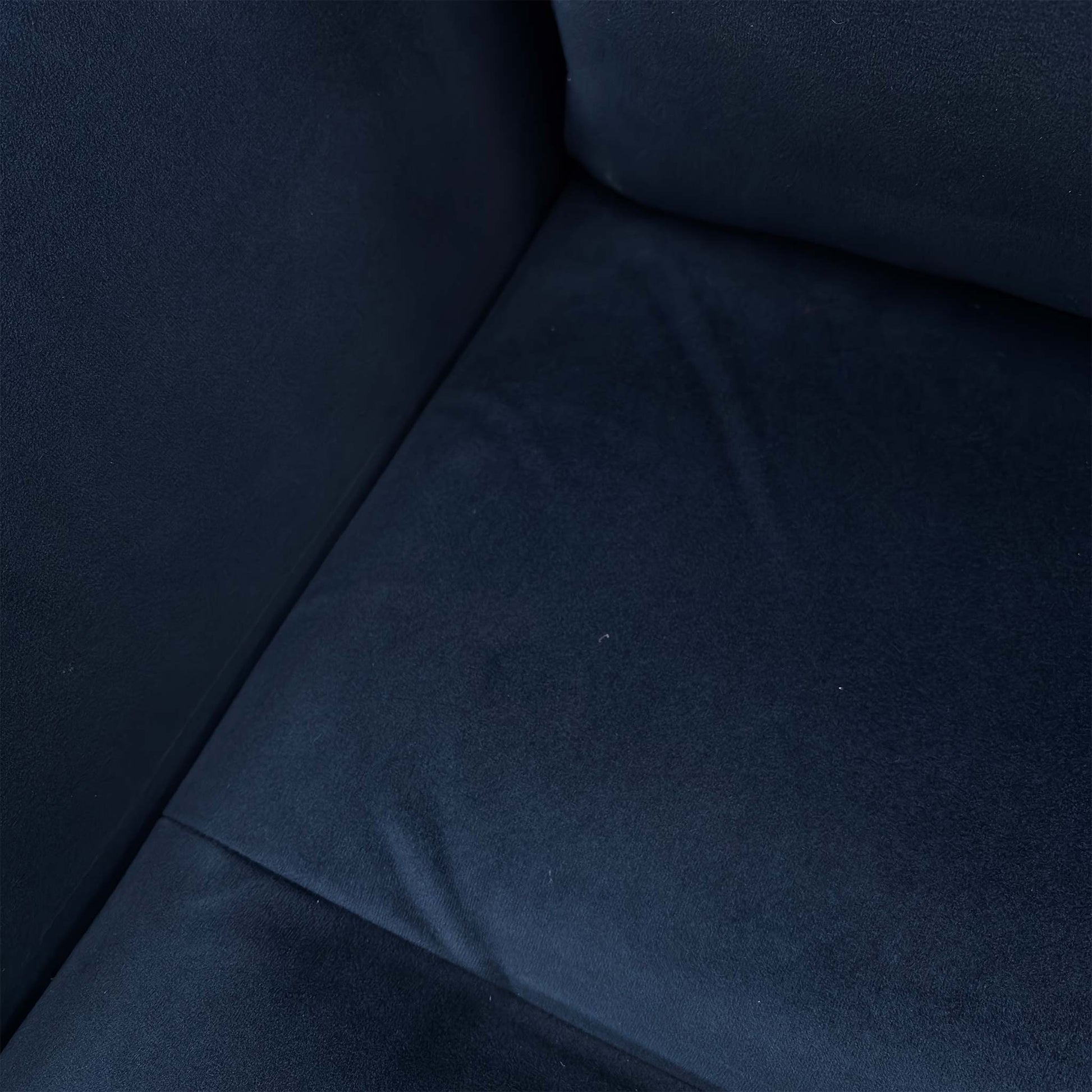 Close-up of the navy blue velvet texture and stitching on the Parker Knoll chair.