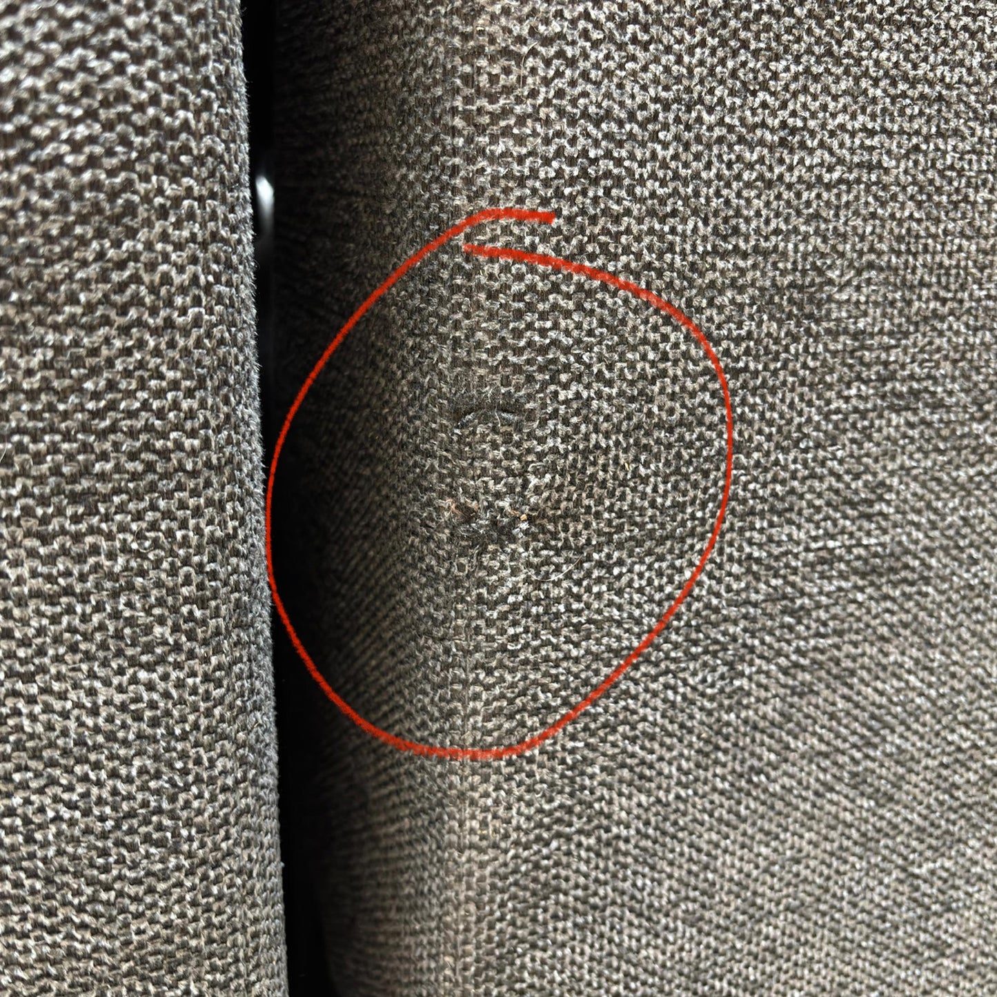 A specific detail shot highlighting a small area of damage on the upholstery as mentioned in the product description.
