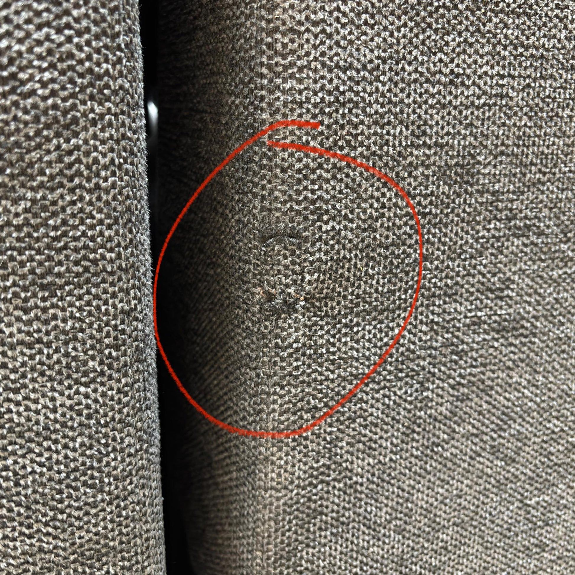 A specific detail shot highlighting a small area of damage on the upholstery as mentioned in the product description.