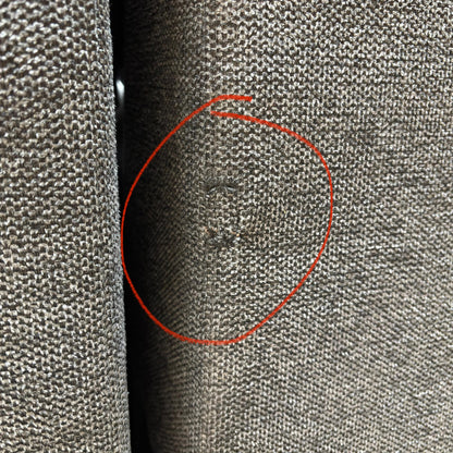 A specific detail shot highlighting a small area of damage on the upholstery as mentioned in the product description.