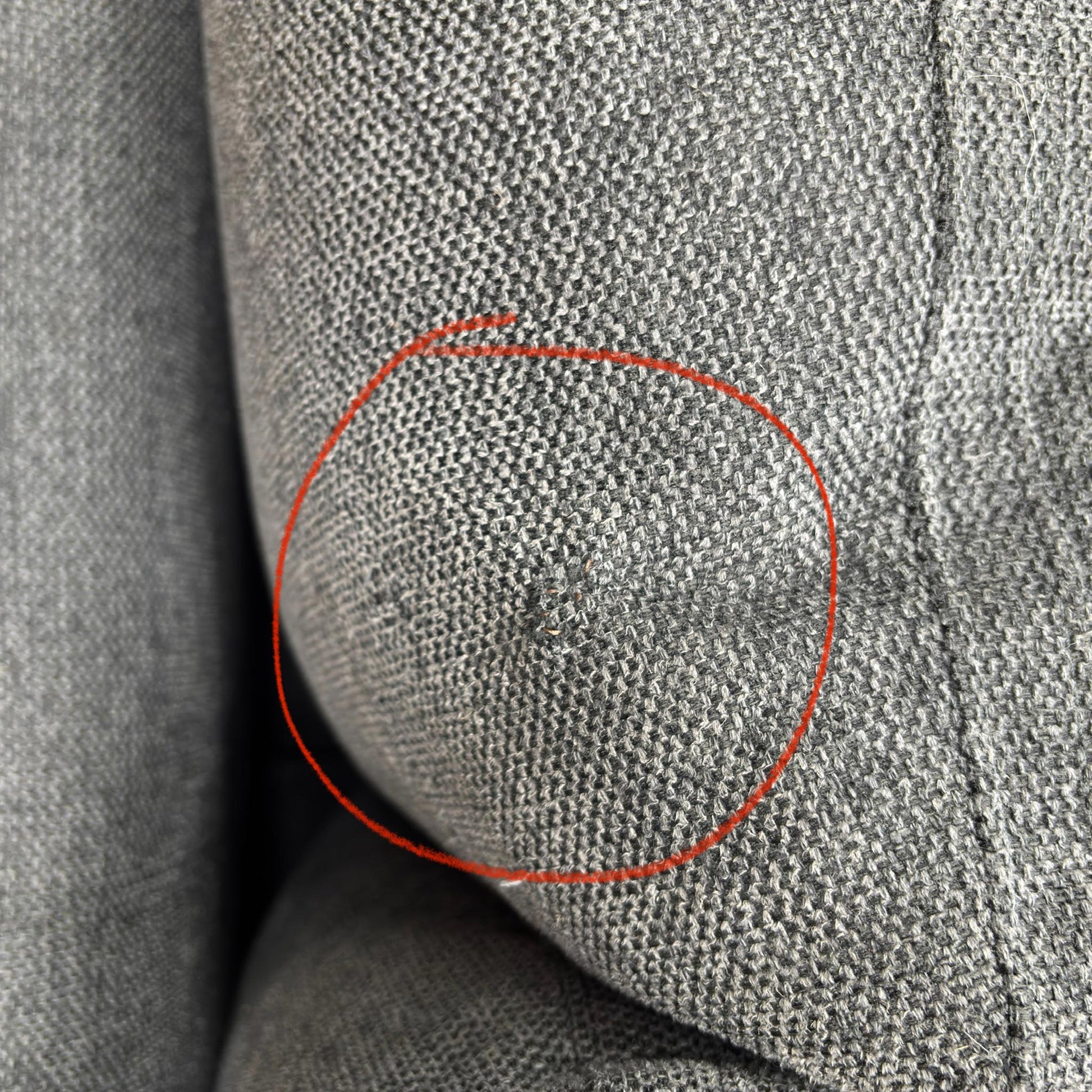 A specific detail shot highlighting a small area of damage on the upholstery as mentioned in the product description.