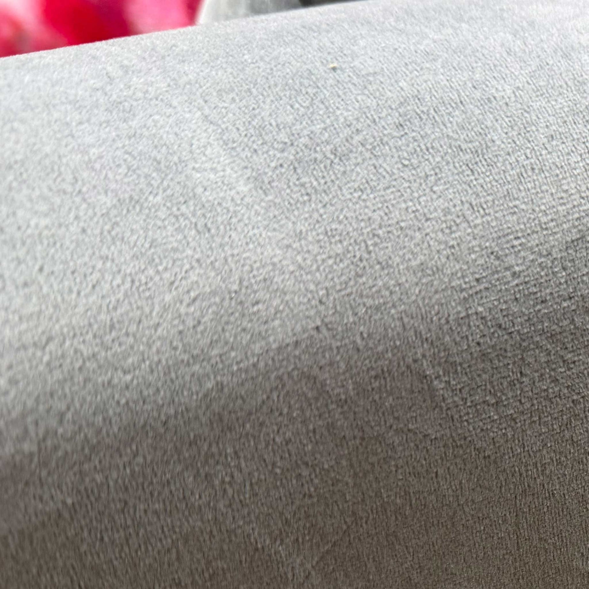 Close-up of the plush grey velvet fabric and high-quality stitching on the 2-seater sofa.