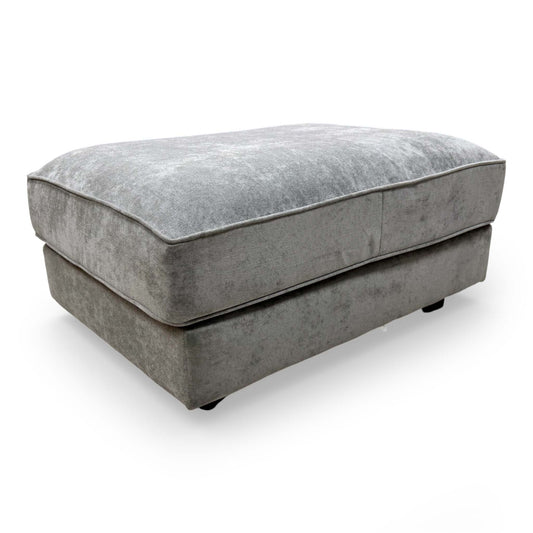 Front view of the Furniture Village 'Legend' Kingston footstool, upholstered in soft grey fabric.