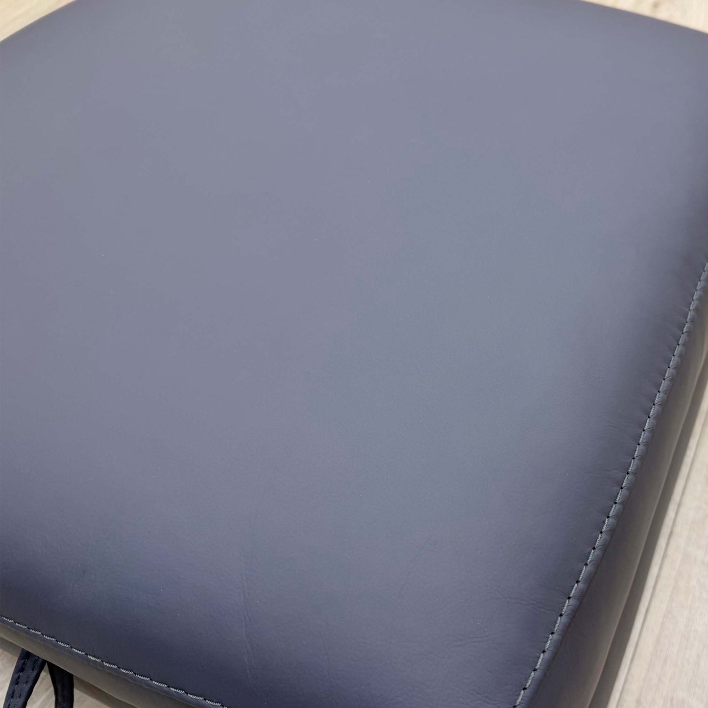 Close-up of the stitching and leather texture on the Cozee footstool, illustrating the durable construction.