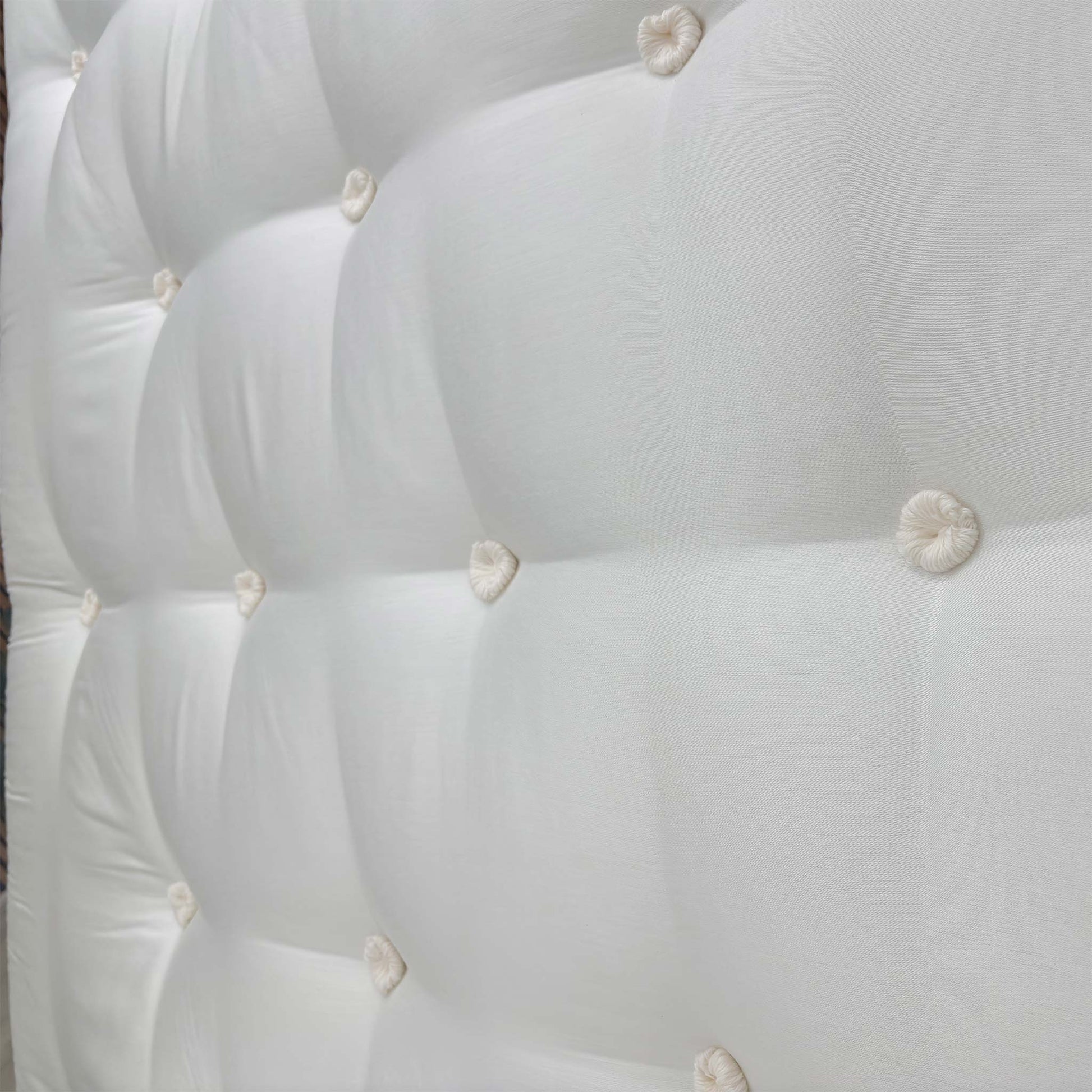 Detailed close-up of the mattress surface and tufted finish, demonstrating the high-performance materials and wool-rich comfort layer.