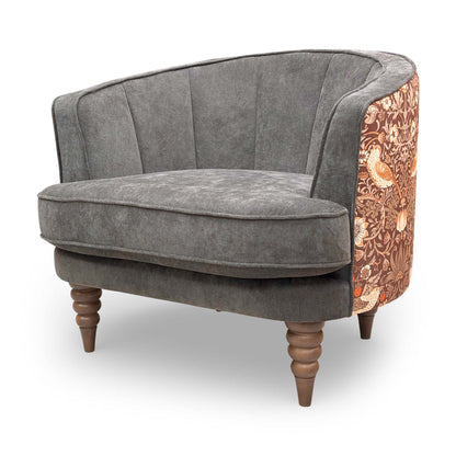 Side profile of the Talon armchair, showing the contrast between the solid brown fabric front and the decorative floral back.