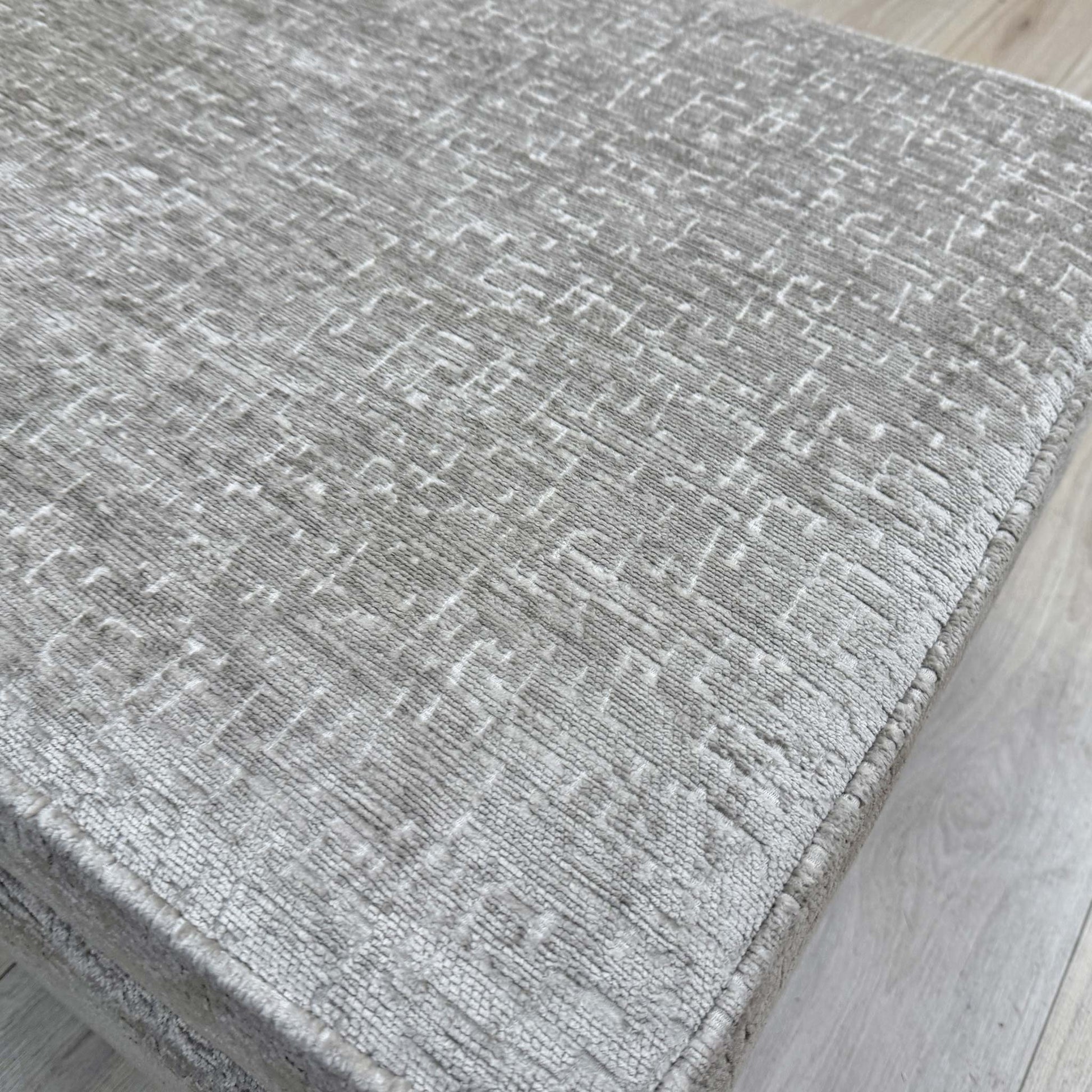 Close-up of the ivory white chenille upholstery on the Sasha footstool, showing the soft, durable weave of the fabric.