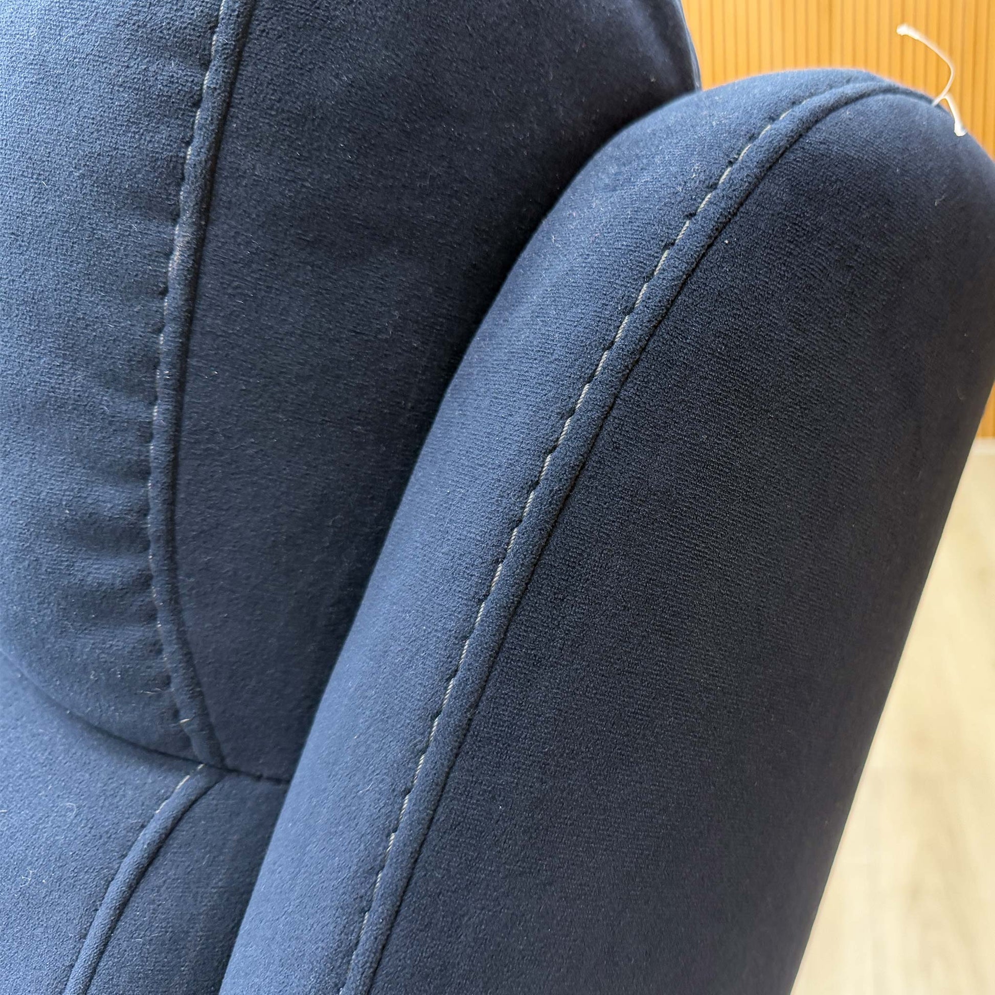 Detailed shot of the luxurious navy velvet upholstery and stitching on the Berlin corner sofa.