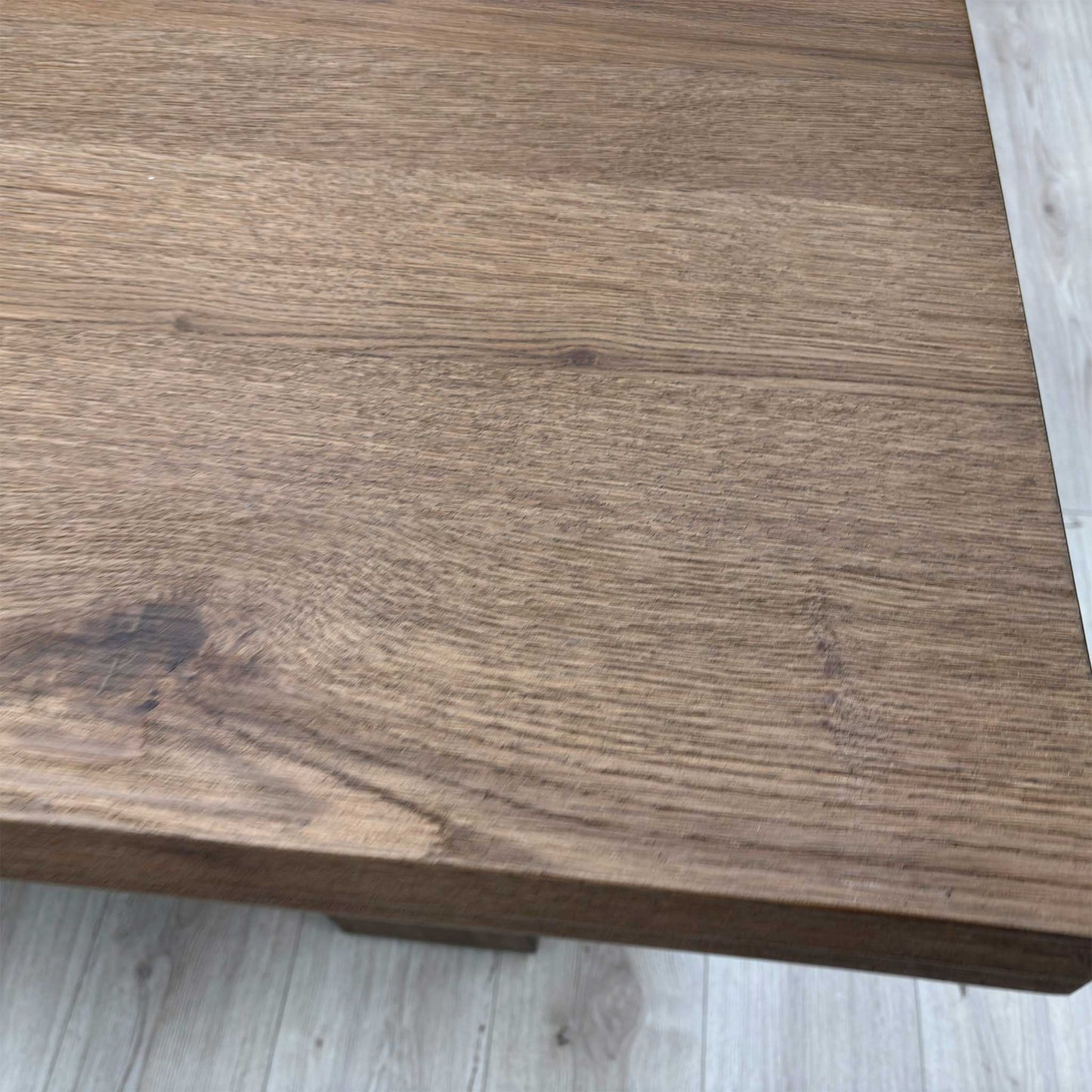 Close-up of the solid oak table top highlighting the natural "cracked" oak grain and rich cashew wood finish.