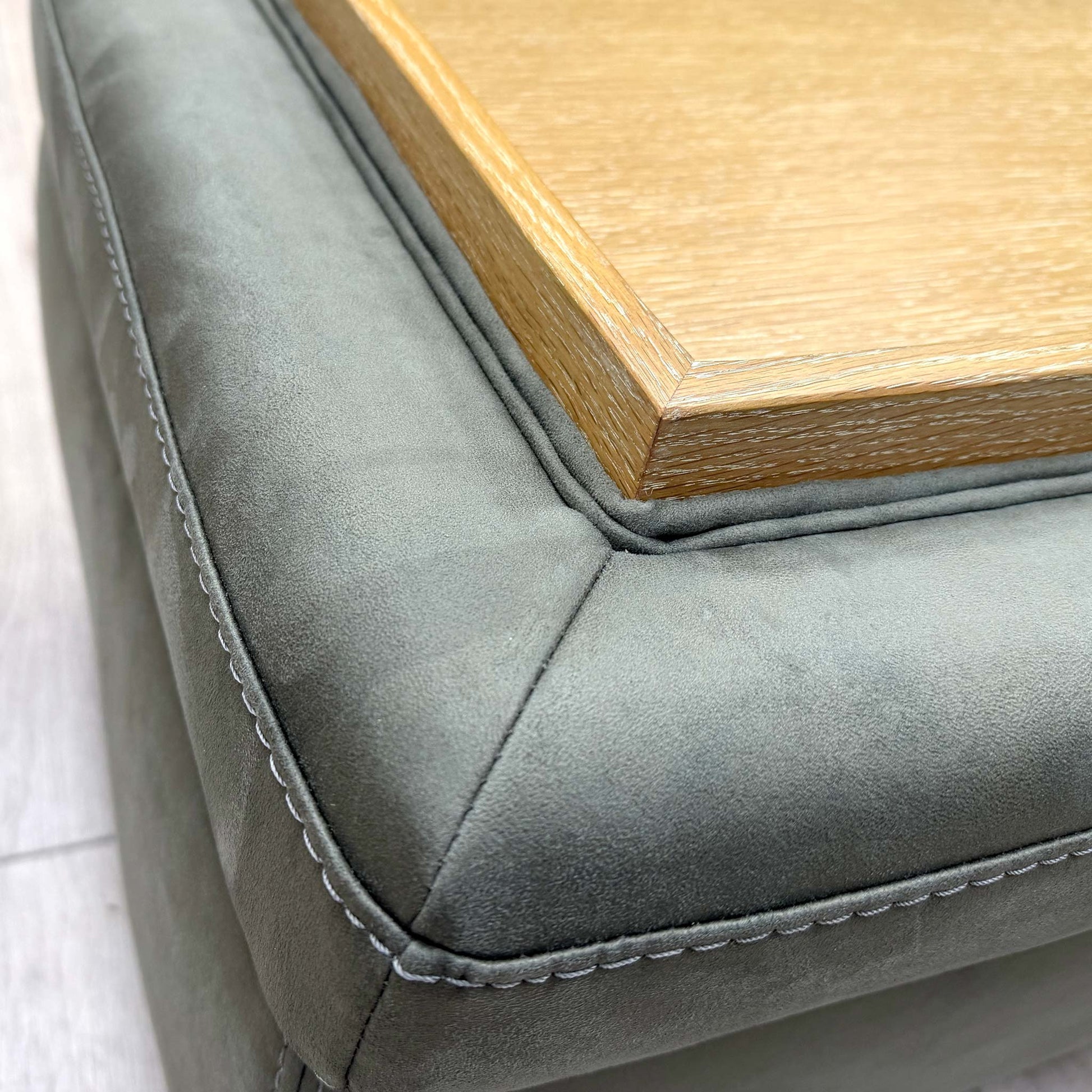 Close-up shot of the tapered light-wood feet, showing the sturdy support and floor clearance of the Malmo footstool.