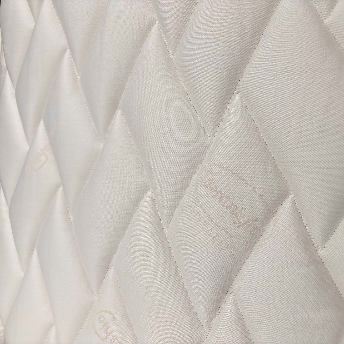Close-up of the tufted mattress surface, detailing the soft-touch fabric designed for pressure relief and spinal alignment.