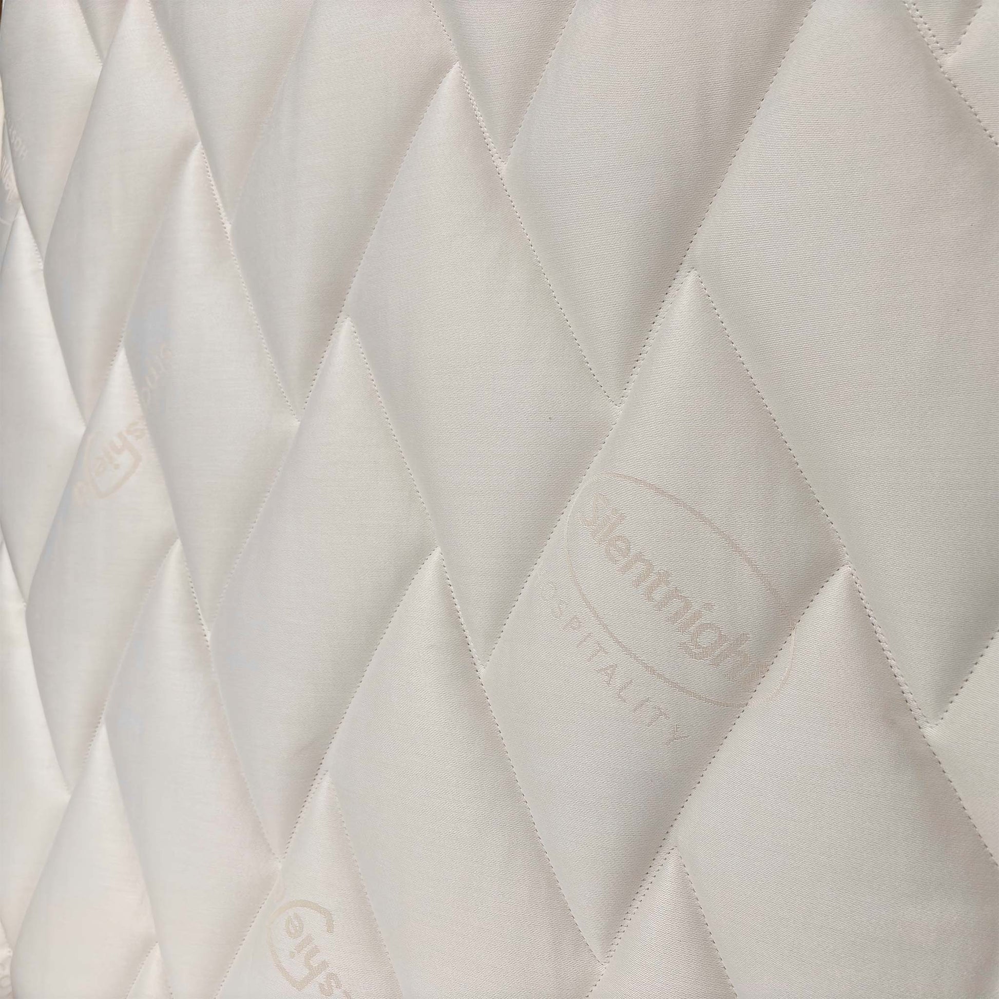 Close-up of the tufted mattress surface, detailing the soft-touch fabric designed for pressure relief and spinal alignment.