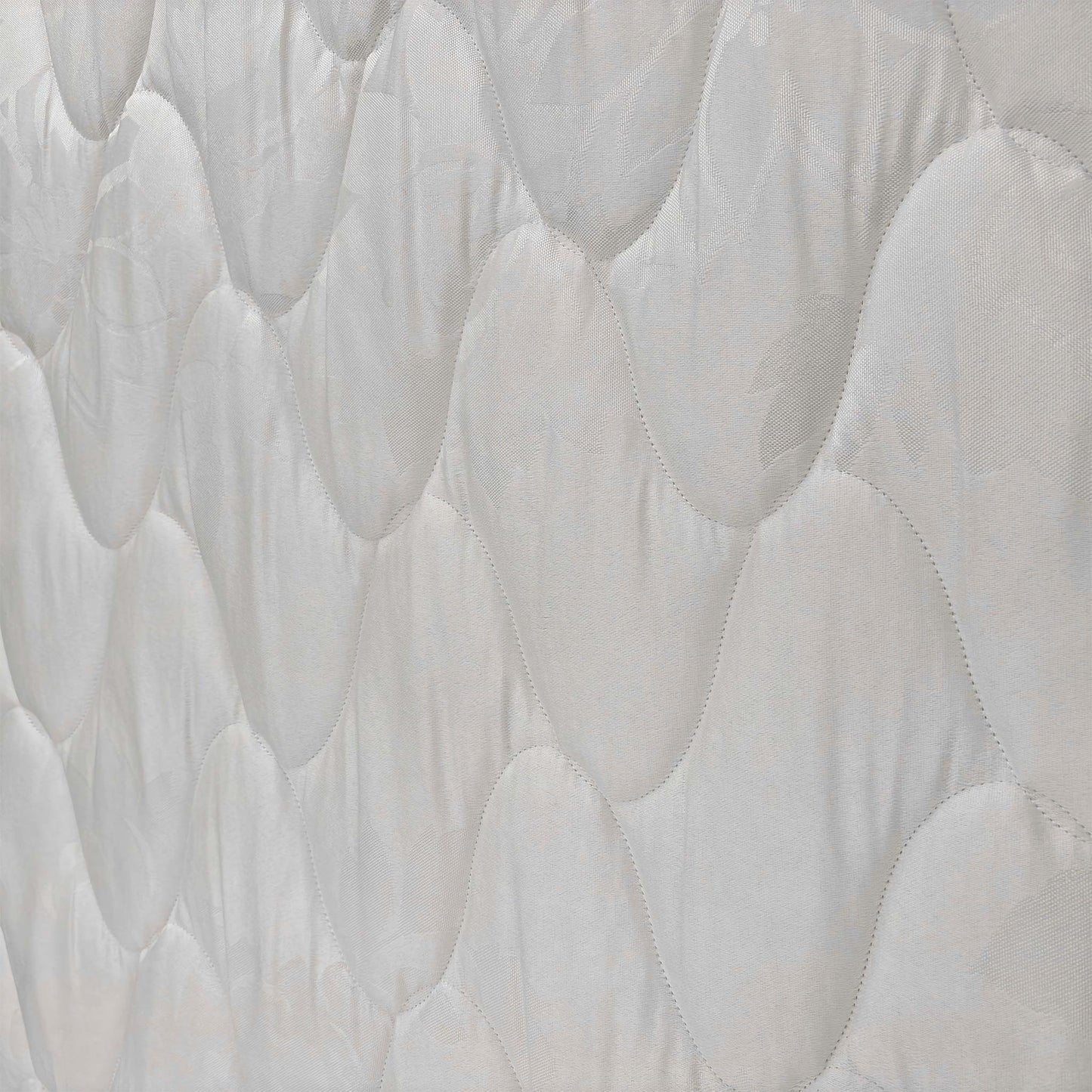 Close-up of the fabric texture and stitching, showcasing the quality construction of the Miracoil spring system mattress.