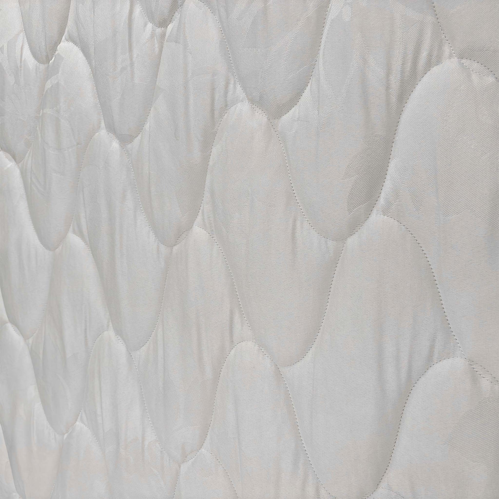 Close-up of the fabric texture and stitching, showcasing the quality construction of the Miracoil spring system mattress.