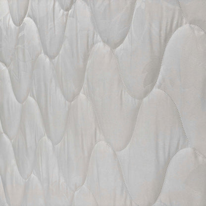 Close-up of the fabric texture and stitching, showcasing the quality construction of the Miracoil spring system mattress.