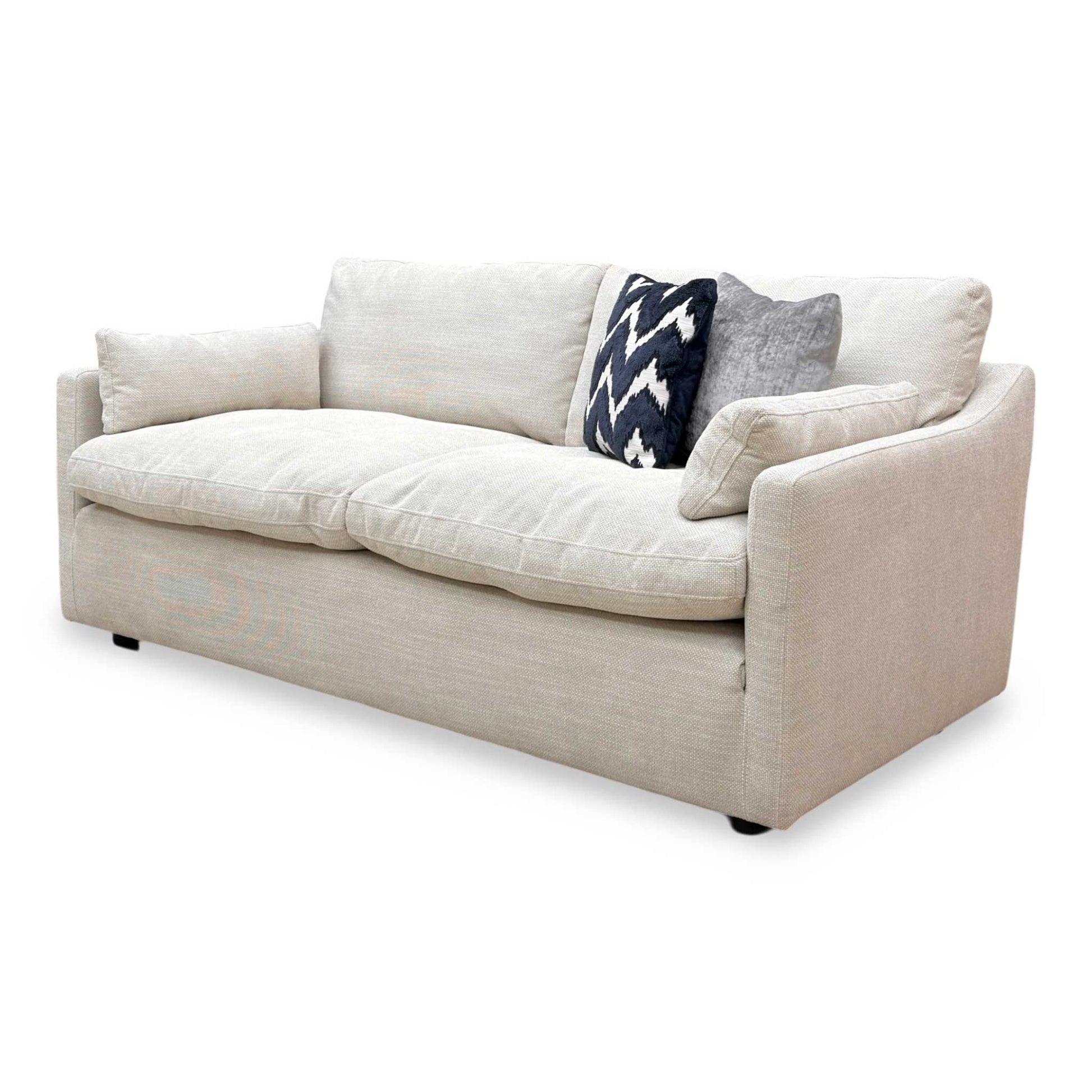 Side view of Nick Scali Dream 2 seater sofa upholstered in soft natural fabric with a streamlined silhouette.