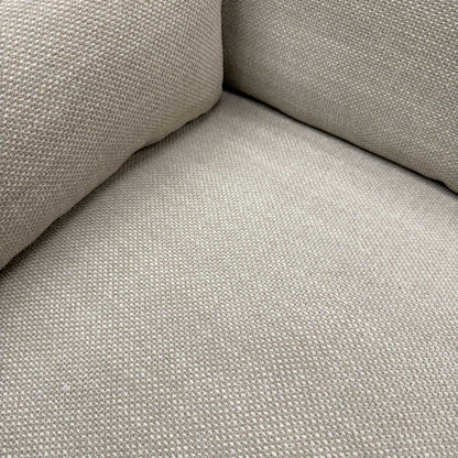 Close-up of the natural fabric upholstery and the high-quality stitching on the sofa armrest.