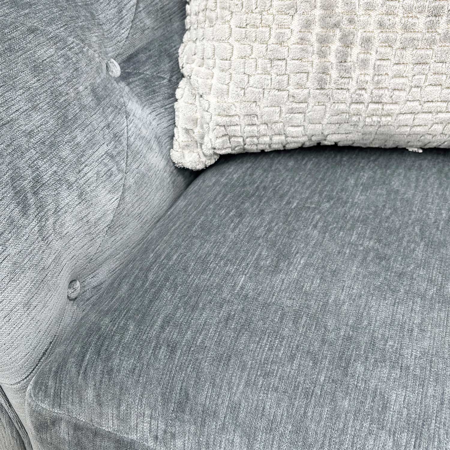 Close-up of the dolphin grey fabric and flawless buttoning on the sofa's arms.