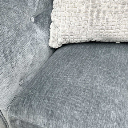 Close-up of the dolphin grey fabric and flawless buttoning on the sofa's arms.